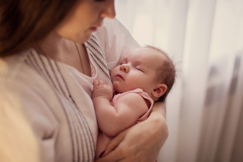 mother settling baby in arms